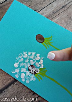 someone is painting flowers on a piece of paper with acrylic paint and glue