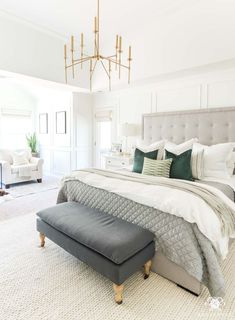 an instagramted photo of a bedroom with white walls and gray bed linens