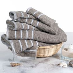 towels are stacked on top of each other next to a glass of water and a candle