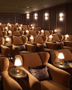 an empty theater with rows of chairs and lamps on the side tables in front of them