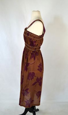 1970's Brown and Purple Hibiscus Sundress Brown dress with large dark purple hibiscus print over this lovely sundress. There is elastic at the bust and waist to fit several dress sizes. Label: Unknown - No Tag Present Measurements are taken flat; Armhole: 8 inches Neck: 7 inches Bust: 9 1/2 - 17 inches Waist: 8 - 18 inches Hips: 15 inches Length (shoulder to hem): 44 inches Condition Just below the hip line is a faded circle that goes around the skirt. Vintage is anything over 20 years old, I tr Purple Sundress, Purple Hibiscus, Hibiscus Print, Skirt Vintage, Brown Dress, Tea Length, 20 Years Old, Dark Purple, Vintage 70s