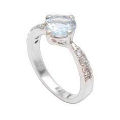 The perfect addition to any outfit this unassuming solitaire ring from Bali sparkles with the majestic hues of blue topaz. A single faceted gemstone in a prong setting is featured prominently at the front flanked by petite stones that pave the handcrafted sterling silver band totaling over four carats altogether. Formal Solitaire Topaz Birthstone Ring, White Topaz Solitaire Ring In Fine Jewelry Style, Formal Blue Topaz Solitaire Birthstone Ring, Classic Blue Topaz Promise Ring, White Topaz Solitaire Promise Ring, Promise Ring With Center Stone In White Topaz, Classic Blue Topaz Ring With Center Stone, White Topaz Promise Ring With Center Stone, Classic White Topaz Ring With Accent Stones