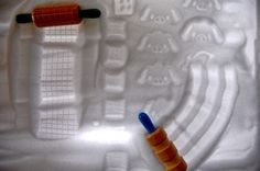 two plastic toothbrushes sitting on top of a white plate with blue and orange handles