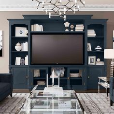 a living room filled with furniture and a flat screen tv on top of a entertainment center