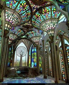 the inside of an ornate building with stained glass windows and arches on each side,