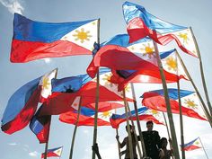 many flags are flying in the wind on a sunny day