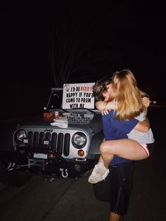 two women hugging each other in front of a jeep with a happy birthday sign on it