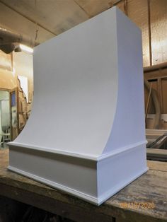 a large white sculpture sitting on top of a wooden table next to a machine shop