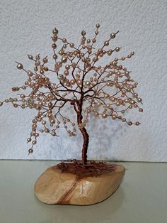 a small tree is made out of wood and glass beads on the top of it