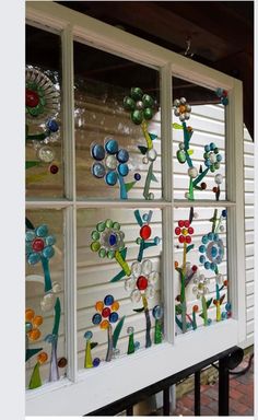 the window is decorated with colorful glass flowers