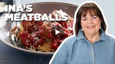 a woman standing in front of a plate of spaghetti and meatballs with the words ina's meatballs on it