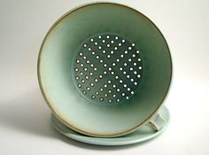 a white and green bowl with holes in it