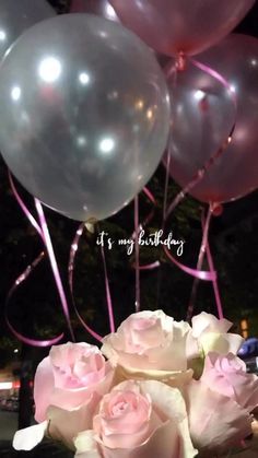 a bouquet of roses and balloons on a table with the words it's my birthday