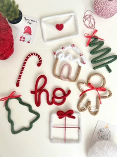 some christmas decorations are laying out on a white surface with red and green ribbon around them