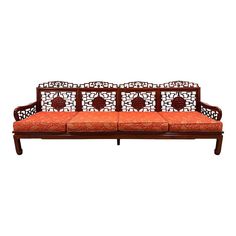 an orange and white couch sitting on top of a wooden frame