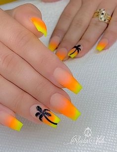 a woman's hand with yellow and orange nail polishes on her nails, palm trees are in the background