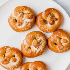 six glazed donuts on a white plate