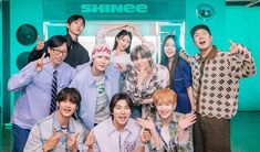 group of young people posing for photo in front of shinee store with one man giving the peace sign