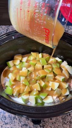 apples are being poured into the slow cooker