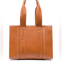 Nwt Chloe Woody Medium Tote Is Made From Smooth Brown Calfskin Leather. - Chloe Logo - 2 Long Handles - 1 Spacious Main Compartment - 1 Internal Flat Pocket - Measurements: - Width: 14.6" (37 Cm) - Height: 10.2" (26 Cm) - Depth: 4.7" (12 Cm) - Strap Drop: 9.8" (25 Cm). - Made In Italy - Comes With A Dust Bag. - Designer Sku Number: C23us383i60 - Designer Color: 247 Modecraze Is An Online Platform That Offers The Best Designer Products From Europe To Customers All Over The World. Our Exclusive Pa Neutral Bag, Chloe Brown, Embroidered Leather, Designer Totes, Bags Aesthetic, Medium Tote, Chloe Bag, Brown Bags, Tote Bag Leather