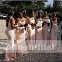 a group of women standing next to each other wearing dresses and holding white bouquets