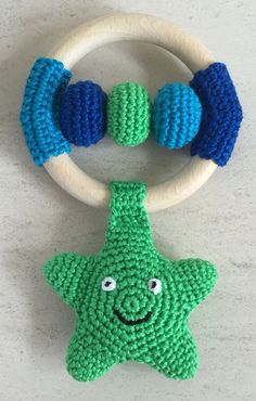 a crocheted green and blue starfish rattler toy