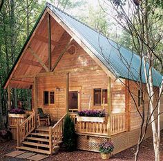 a small wooden cabin in the woods with stairs leading up to it's porch