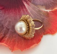 Kālā (the Sun) Spectacular 14mm Natural Color Champagne South Sea Cultured Pearl Ring, Size 7. What an incredible statement piece, 18k Yellow Gold plating over 925 Sterling Silver with an amazing high luster cultured pearl set inside. Measuring 1" in length. The cultured pearl is 14mm size, natural color Champagne and origin is the South Sea, Philippines. Non-resizable 18k Yellow Gold plated over 925 Sterling Silver ring in US ring size 7. Check our shop also for the Kālā pendant if you want a matching set. Only one in stock! Pearl Type: Golden South Sea Cultured  Pearl Treatment: No Treatment   Pearl Size: 14mm Pearl Color: Natural Color Champagne  Pearl Origin: Philippines, South Sea  Metal Type: 18k Yellow Gold plated over 925 Sterling Silver  US Ring Size: 7 Manufactured in Kailua, Haw Cultured Pearl Ring, Buy Pearls, Golden South Sea Pearls, Pearl Shop, Color Champagne, South Seas, South Sea Pearls, Pearl Set, Pearl Types