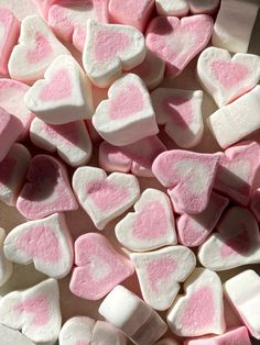 pink and white heart shaped marshmallows are on a counter top, ready to be eaten