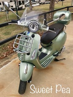 a green scooter parked in front of a fence with the words sweet pea on it