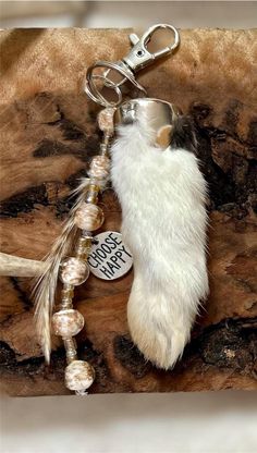 a keychain with a white fur and beads hanging from it's side