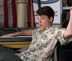 a young man sitting in front of a keyboard