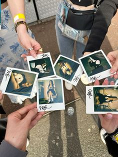 several people holding up polaroids with pictures on them