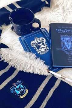 two harry potter notebooks and a pen on a white furnishing next to a coffee mug