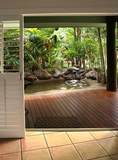 an open door leading into a tropical garden