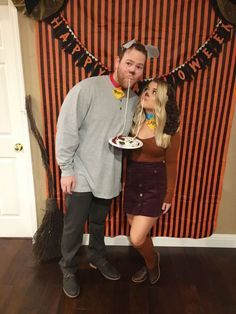 a man and woman standing in front of a halloween banner