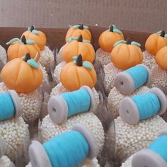 cupcakes decorated with pumpkins and sprinkles are in a box