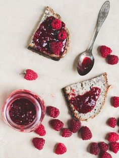 raspberry jam on toast with fresh raspberries around it and a spoon