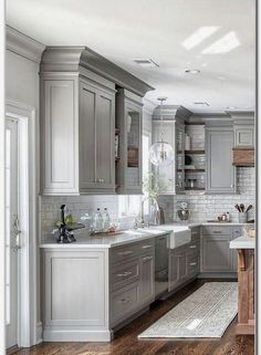 a large kitchen with gray cabinets and white counter tops is pictured in this image from the front view