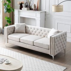 a living room with white furniture and a fireplace