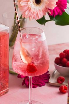 a pink drink with raspberries in it