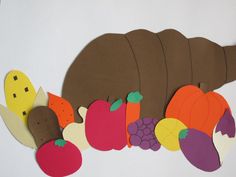 a paper cutout of a caterpillar surrounded by fruits and vegetables