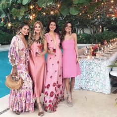 three women standing next to each other in front of a pool