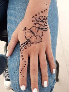 a woman's hand with a butterfly tattoo on it