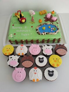 there are many cupcakes with farm animals on them in front of the cake