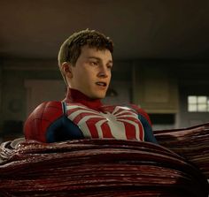 spider - man standing in front of stacks of red and white sheets with his mouth open