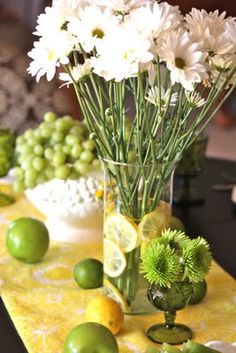 flowers and lemons in a vase on a table