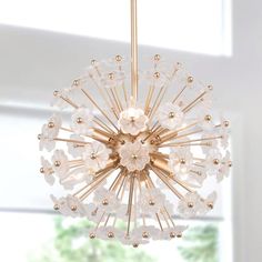 a chandelier hanging from the ceiling in a room with white walls and windows