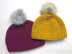 two crocheted hats with pom - poms on them