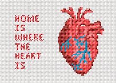 a cross stitch heart with the words home is where the heart is